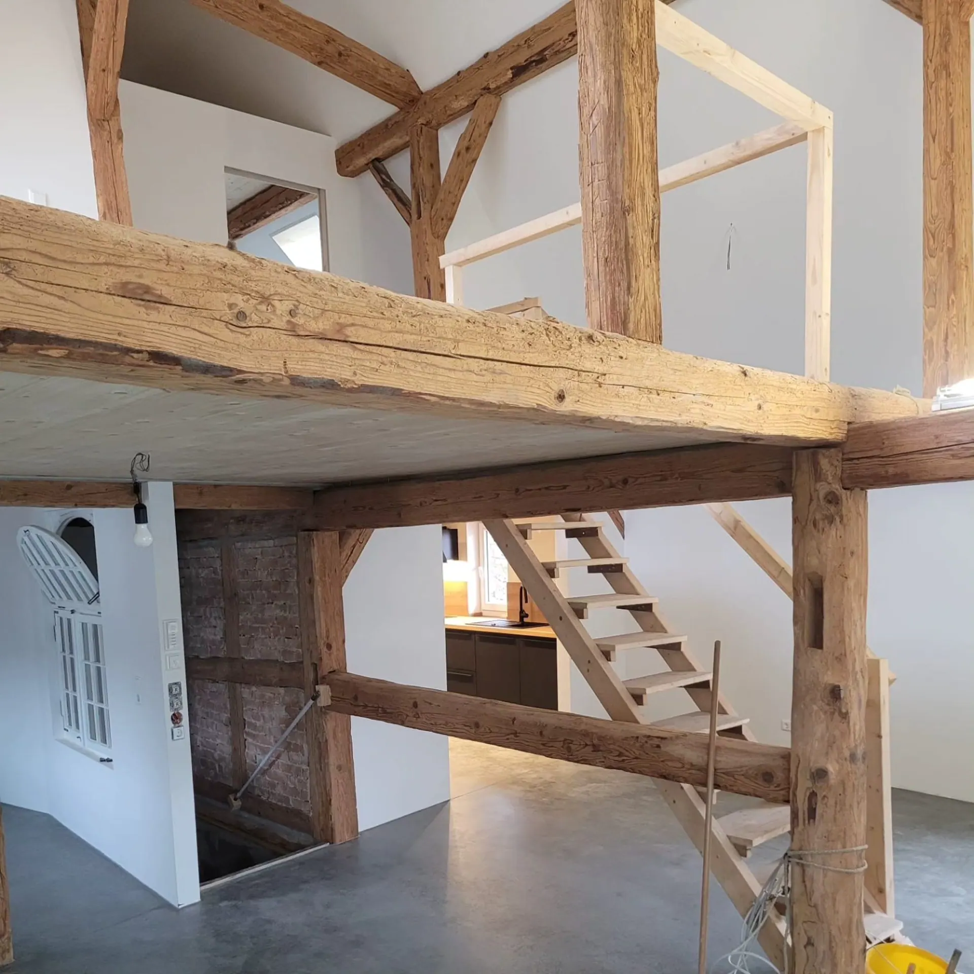 Moderner Wohnraum im Rohbau mit Holzbalken
