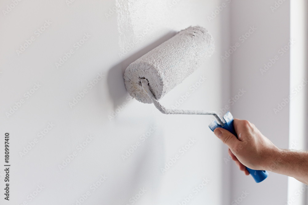 Malerrolle beim Streichen einer hellen Wand