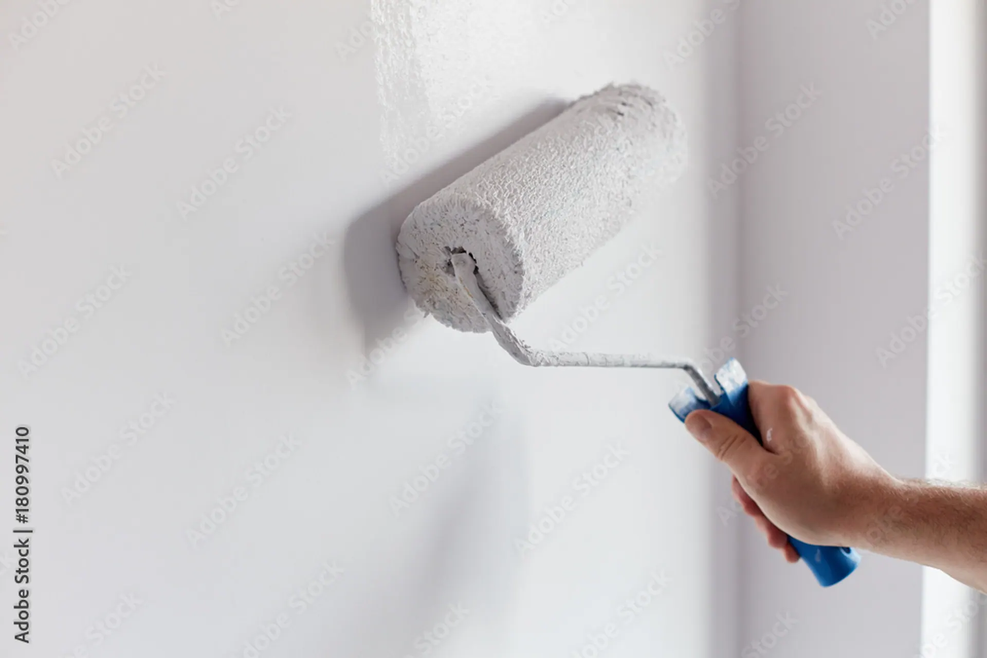 Malerrolle beim Streichen einer hellen Wand